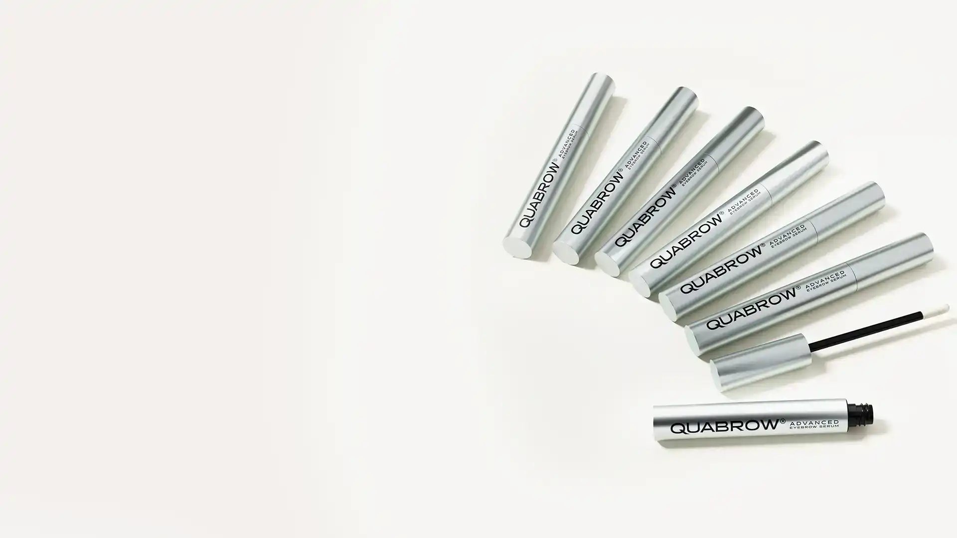 QUABROW Advanced Eyebrow Serum – multiple silver tubes with one open showing applicator