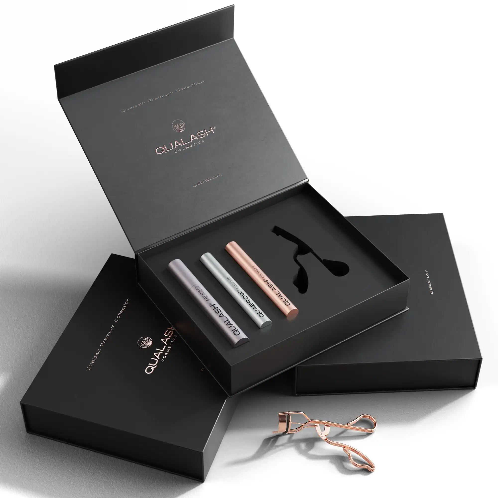 Elegant QUALASH gift box containing eyelash and brow serums, peptide mascara, and lash curler – perfect luxury beauty set