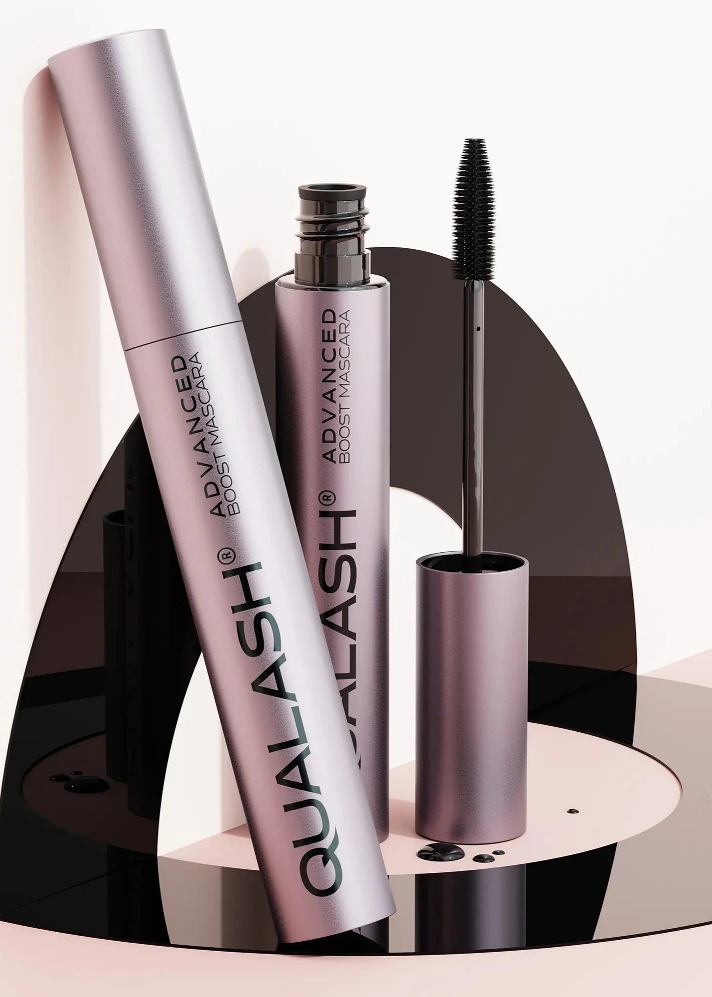 QUALASH Advanced Boost Mascara set displayed on modern artistic black and pink setup