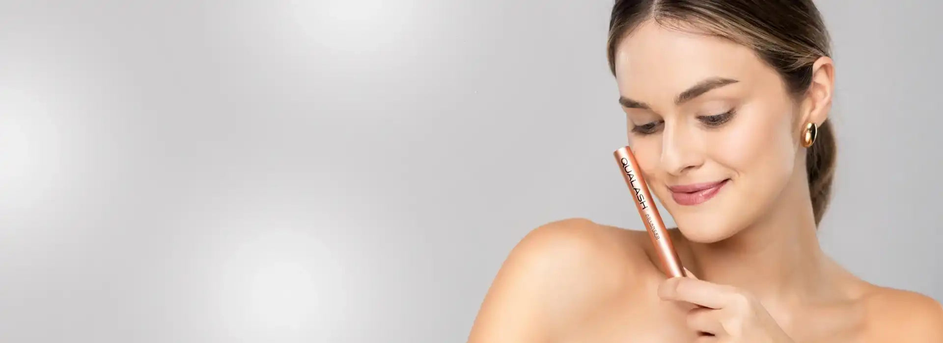 Woman holding Qualash Advanced Eyelash Serum – boost for naturally longer and fuller lashes