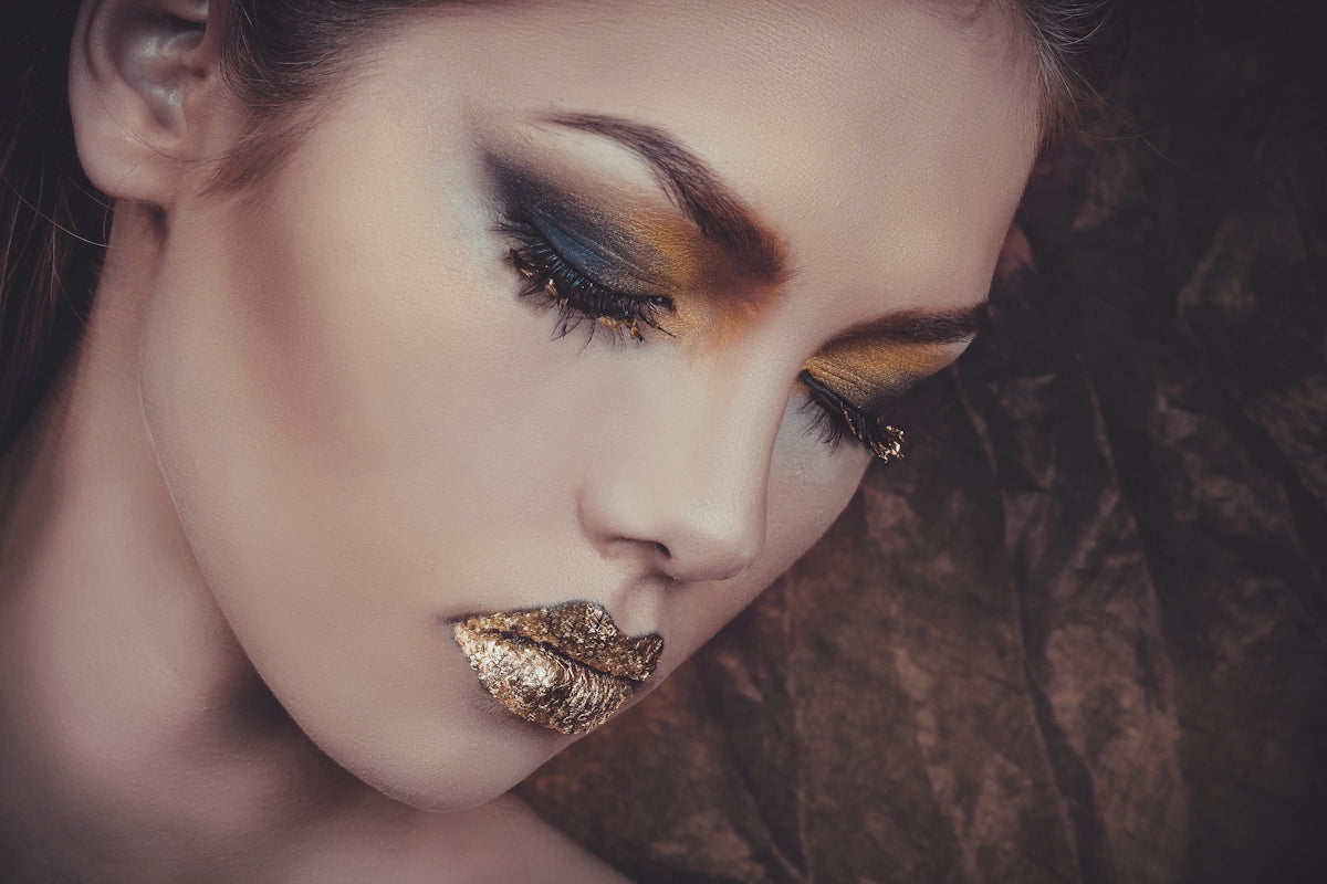 woman with gold lipstick and orange and gray eyeshadow