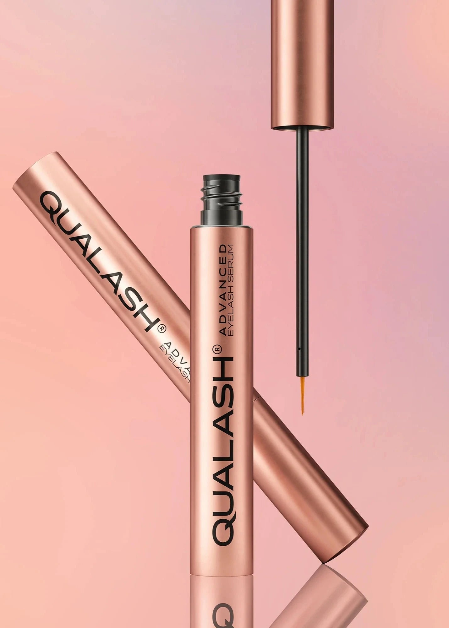QUALASH Advanced Eyelash Serum in rose gold packaging on a pastel background