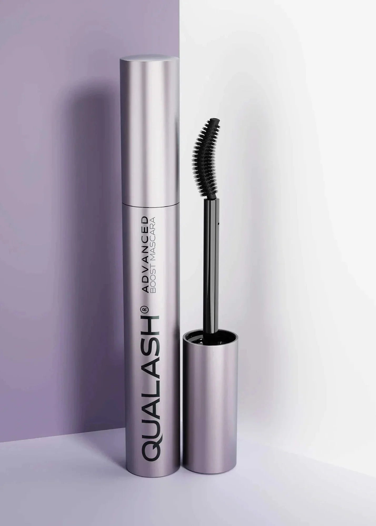 QUALASH Advanced Mascara Curl &amp; Lift 10 ml with curved brush standing upright against a soft lilac and white background